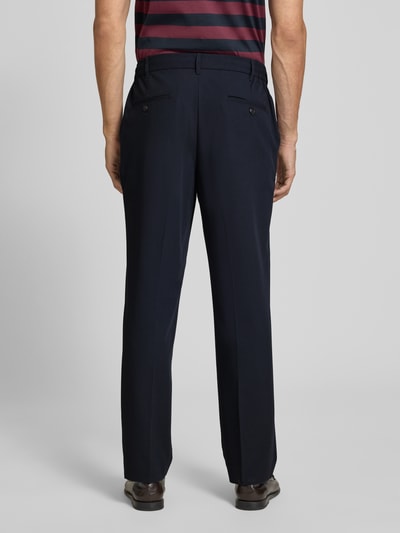 Męski model nosi Straight Fit Hose mit Viskose-Anteil od MCNEAL, elastyczna mieszanka materiałów, zakładki w pasie, kieszenie z tyłu, zapięcie na guzik i zamek błyskawiczny, szerokość w rozmiarze M: 41 cm, długość wewnętrzna nogawki w rozmiarze M: 75 cm, granatowe, gładka tekstura, całkowity widok z tyłu.