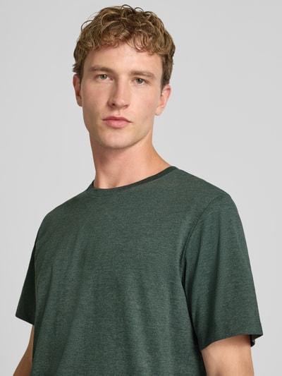 Männermodel trägt Regular Fit T-Shirt aus Baumwoll-Mix Modell 'Organic' von JACK & JONES, meliertes Dunkelgrün, Nahaufnahme Oberkörper.
