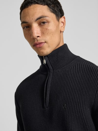 Männermodel trägt Slim Fit Pullover aus reiner Baumwolle in Strick-Optik von Replay, Troyer-Kragen, Nahaufnahme Oberkörper.