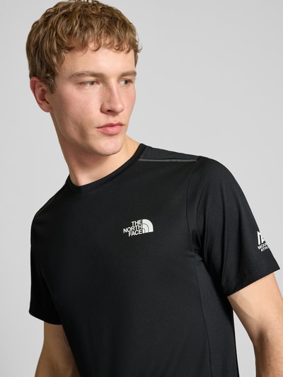 Mannelijk model draagt T-Shirt met Logo en Rundhalsausschnitt van The North Face, regular fit, logoprint, zwart, halflange mouwen, Nahaufnahme bovenlichaam.