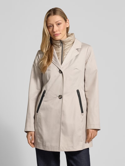 Vrouwenmodel draagt Kurzmantel met heraustrennbarem Westeneinsatz van Gil Bret in beige, getailleerde fit, katoenen stof, reverskraag, ritszakken, knoopsluiting, afneembaar binnenvest, zichtbare zwarte details, geheel lichaam van voren.