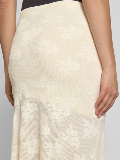 Frauenmodel trägt Maxirock mit elastischem Bund von Gina Tricot, cremefarben, Embroidery Design, Material-Mix mit Stretch-Anteil, Nahaufnahme Rückansicht.