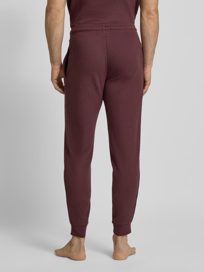 Männermodel trägt Relaxed Fit Pyjama-Hose aus Baumwoll-Mix Modell 'AUSTIN PANTS' von HUGO, Unifarben, Waffel-Struktur, Ganzkörperansicht Rückansicht.