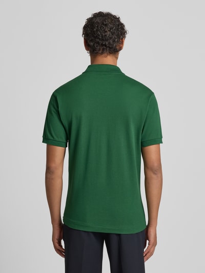 Männermodel trägt Poloshirt mit Label-Stitching Modell 'L.12.12 CORE' von LACOSTE in Unifarben, Reine Baumwolle, Regular Fit, Ganzkörperansicht Rückansicht.