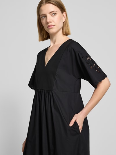 Vrouwenmodel draagt Fließendes Freizeitkleid aus reiner Baumwolle Modell 'TARTUFO' van Weekend Max Mara, effen zwart, broderie, V-hals, korte mouw, maxilengte, jersey en popeline, puur katoen, nahaufnahme bovenlichaam.