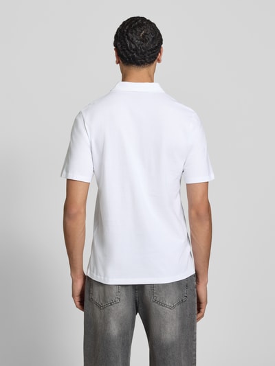 Männermodel trägt Poloshirt mit Label-Print Modell 'BRANDON' von Jack & Jones, Reine Baumwolle, Regular-Fit, Rückenlänge 71 cm, Ganzkörperansicht Rückansicht.
