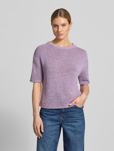 Kobieta modelka nosi Loose Fit Pullover aus Baumwoll-Mix von Marc O'Polo, efekt: jednolity kolor, krój loose fit, okrągły dekolt, krótki rękaw, prążkowane zakończenia, wykończenie materiału: dzianina, materiał: mieszanka bawełny, pastelowy fiolet, gładka tekstura, sweter oraz jeansy, całkowity widok z przodu.