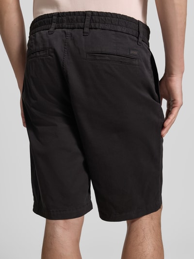 Männermodel trägt Tapered Chinoshorts aus Baumwoll-Mix von BOSS Orange, Optik: Unifarben, Twill, Label-Patch, Ganzkörperansicht Rückansicht