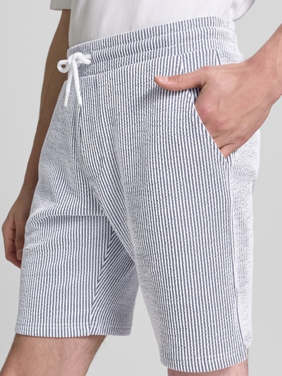 Männermodel trägt Shorts mit elastischem Bund und Kordelzug von MCNEAL im Baumwoll-Mix, gestreift, Loose-Fit, Nahaufnahme Oberschenkel.