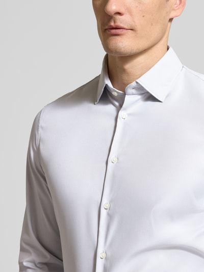 Männermodel trägt Slim Fit Business-Hemd mit Kentkragen von Jake*s aus Material-Mix mit Stretch-Anteil, Knopfleiste, Nahaufnahme Oberkörper.