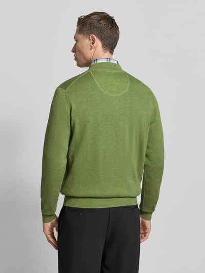 Männermodel trägt grüne Strickjacke mit Reißverschluss von Fynch-Hatton aus reiner Baumwolle, Regular-Fit, Gerippte-Abschlüsse, Stehkragen, Label-Stitching, Eingrifftaschen, Rückenlänge 67 cm, Ärmellänge 69 cm, Ganzkörperansicht Rückansicht.