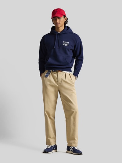 Mannelijk model draagt Relaxed Fit Hoodie aus Baumwoll-Mix van Polo Ralph Lauren, effen donkerblauw, labelprint, kangoeroezak, sweatstof, vooraanzicht volledige lichaamsopname.
