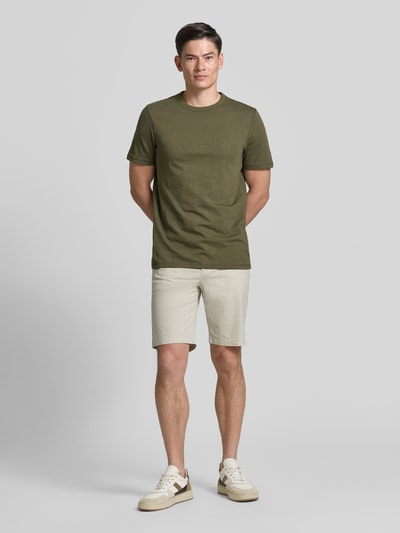 Männermodel trägt Regular Fit T-Shirt aus reiner Baumwolle Modell 'TEGOOD' von BOSS Orange in Optik: Unifarben, Logo-Print, Ganzkörperansicht von vorne.