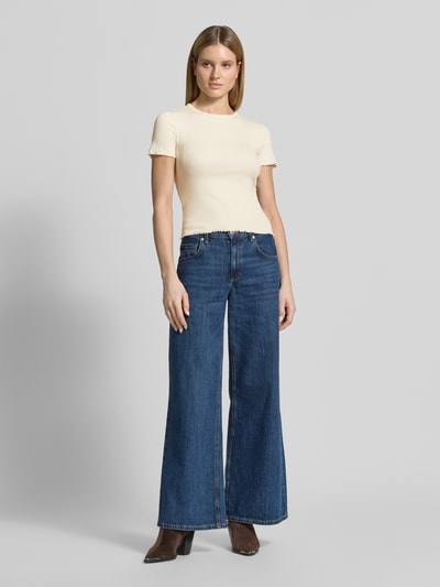 Modelka kobieca nosi T-Shirt mit Wellensaum od Jake*s Casual, mieszanka bawełny, dopasowany krój, drobne prążkowanie, okrągły dekolt, falisty brzeg, długość tyłu w rozmiarze S: 52 cm, kolor jasny, Ganzkörperansicht von vorne.