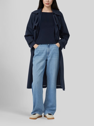 Frauenmodel trägt Regular Fit Pullover aus Baumwoll-Viskose-Mix von s.Oliver RED LABEL in Dunkelblau, kombiniert mit Jeans und Mantel, Ganzkörperansicht von vorne.