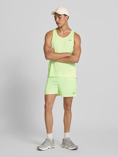Männermodel trägt Tanktop mit Logo und Rundhalsausschnitt von New Balance in Gelb, Regular-Fit, Rückenlänge bei Größe M: 66 cm, Ganzkörperansicht von vorne.