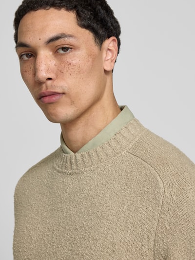 Männermodel trägt Relaxed Fit Pullover in Strick-Optik von Forét, Beige, Bouclé-Optik, Rundhalsausschnitt, Baumwoll-Mix, Nahaufnahme Oberkörper.