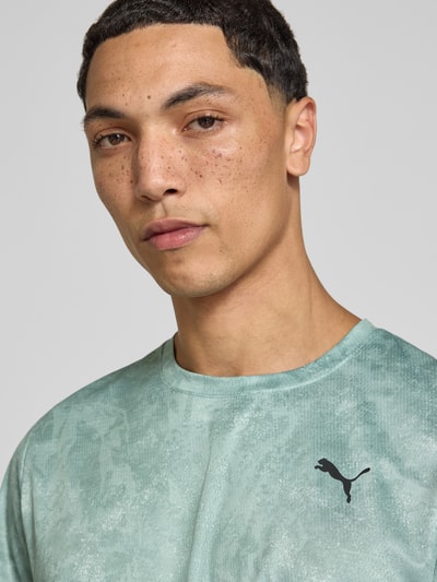 Männermodel trägt Regular Fit Sport-T-Shirt mit Logo-Print Modell 'M TAD ESSENTIALS' von PUMA, mintgrün, leichte Struktur, Nahaufnahme Oberkörper, Herren Sport-T-Shirt von PUMA Performance.