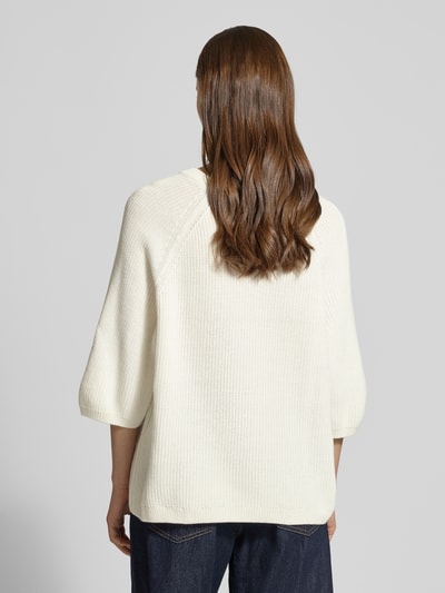 Männermodel trägt Oversized Strickpullover aus reiner Baumwolle Modell 'MARGE' von JJXX, kremowy kolor, krótki rękaw, okrągły dekolt, sweter o grubym splocie, długość tyłu 59 cm, rękaw 3/4, ściągacze, Ganzkörperansicht Rückansicht.