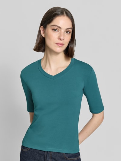 Frauenmodel trägt T-Shirt mit Rundhalsausschnitt von Christian Berg Woman aus Baumwoll-Elasthan-Mix, Slim-Fit, 1/2-Arm, petrolfarben, Rückenlänge 53 cm, Ganzkörperansicht von vorne.