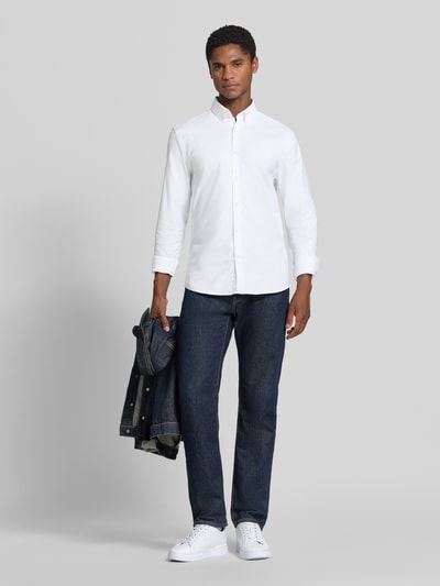 Männermodel trägt Regular Fit Freizeithemd aus Baumwoll-Mix Modell 'Oxford' von Lindbergh, weiß, glatte Textur, Ganzkörperansicht von vorne.