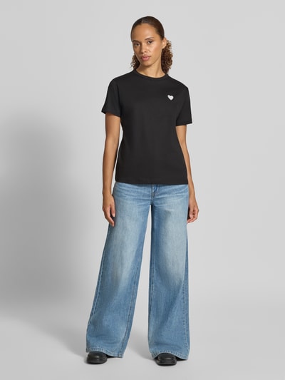 Frauenmodel trägt Regular Fit T-Shirt aus reiner Baumwolle Modell 'Damacia_9' von HUGO, Damen T-Shirt, schwarze Farbe, Ganzkörperansicht von vorne.
