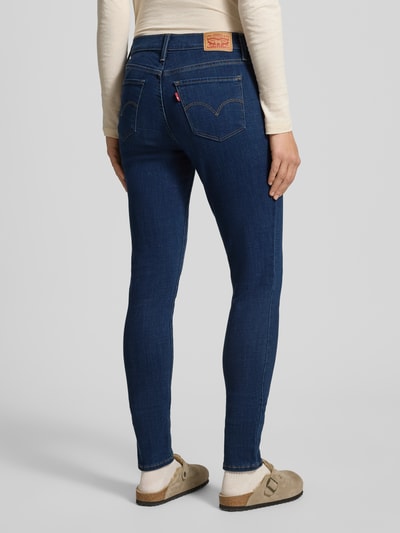 Frauenmodel trägt Skinny Fit Jeans im 5-Pocket-Design Modell 'SHAPING SKINNY' von Levi's®, blaue Farbe, Baumwoll-Mix, Ganzkörperansicht Rückansicht, Damen Jeans von Levi's® 300, Shaping Skinny Fit, Knopf- und Reißverschluss, Bundweite 38 cm, Innenbeinlänge 79 cm.