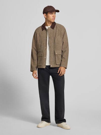 Männermodel trägt Barn Jacket mit Pattentaschen Modell 'SALAMANCO' von JACK & JONES in Braun und Schwarz, Ganzkörperansicht von vorne. Material-Mix mit Viskose, Regular Fit, Kentkragen in Cord-Optik, Reiß- und Druckknopfverschluss, Brust- und Pattentaschen.