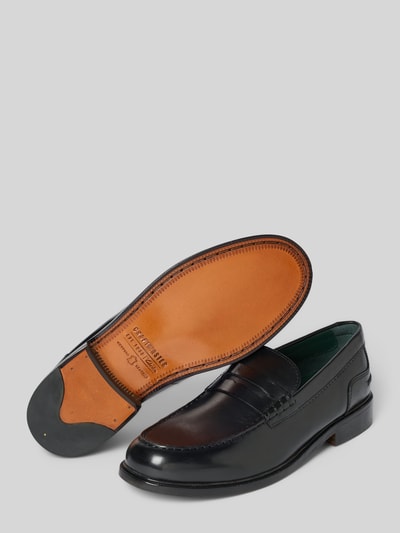Produktfoto, Slipper aus beschichtetem Leder Modell 'CraftJames' von Clarks in Schwarz mit abgerundeter Form, Zierriemen und glatter Sohle, Absatzhöhe 3 cm, Schafthöhe 7 cm, Schaftweite 12 cm, Detailansicht von Schuhform und Sohlenstruktur