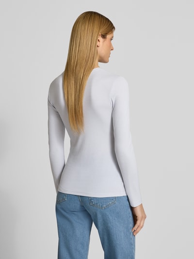 Frauenmodel trägt Slim Fit Langarmshirt aus Lyocell-Mix von Marc O'Polo, Optik: Unifarben, Passform: Slim-Fit, Rundhals, Ärmelform: Langarm, Materialverarbeitung: Ripp, Farbe Weiß, glatte Textur, Ganzkörperansicht Rückansicht.