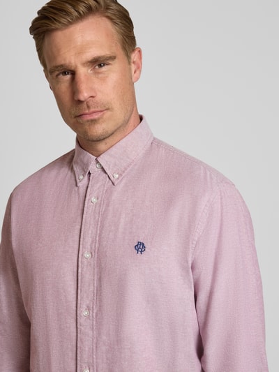 Männermodel trägt Regular Fit Freizeithemd aus reiner Baumwolle von MCNEAL in Hellrosa mit Logo-Stitching, Nahaufnahme Oberkörper.