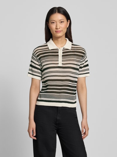Frauenmodel trägt Regular Fit T-Shirt in Strick-Optik von Comma, gestreift in Creme und Schwarz, Reine Baumwolle, Polokragen, kurzärmelig, Ganzkörperansicht von vorne.