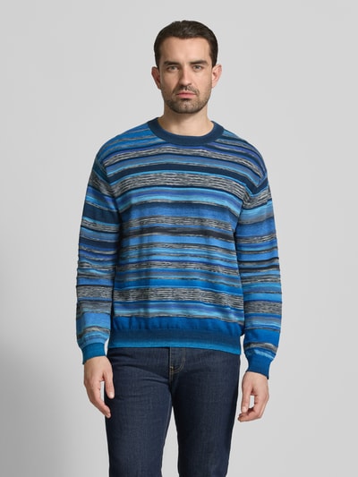 Männermodel trägt Strickpullover im Allover-Look mit Rundhalsausschnitt von PAUL SMITH, blaue Streifen, Regular Fit, Ganzkörperansicht von vorne.