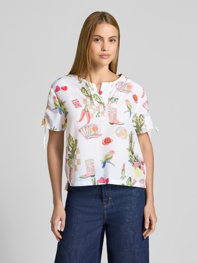 Frauenmodel trägt Regular Fit Bluse im Allover-Look von Marc Cain aus Baumwoll-Viskose-Mix mit Kordelzug an den Ärmeln, bunte Muster, Rückenlänge 59 cm, Ärmellänge 19 cm, Ganzkörperansicht von vorne.