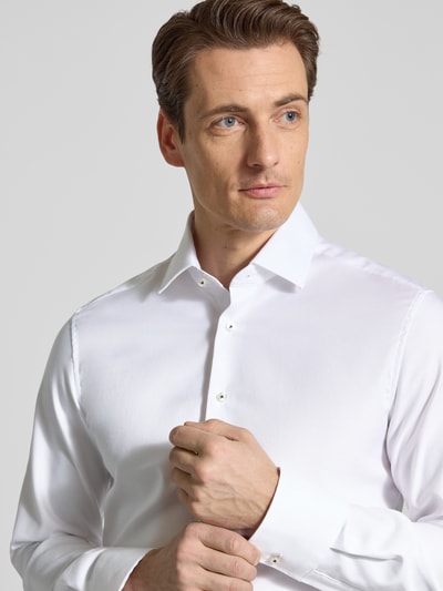 Männermodel trägt Slim Fit Business-Hemd mit Kentkragen von ETERNA aus reiner Baumwolle, weiß, Knopfleiste, Langärmeliges Design, Nahaufnahme Oberkörper.