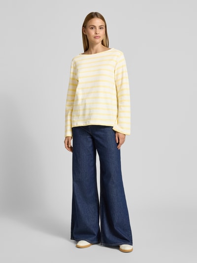 Vrouwenmodel draagt Relaxed Fit Sweatshirt uit pure katoen van s.Oliver RED LABEL, two tone ontwerp, label patch, lange mouw, u-boot hals, sweatstof, geel-witte strepen, vooraanzicht hele lichaam.