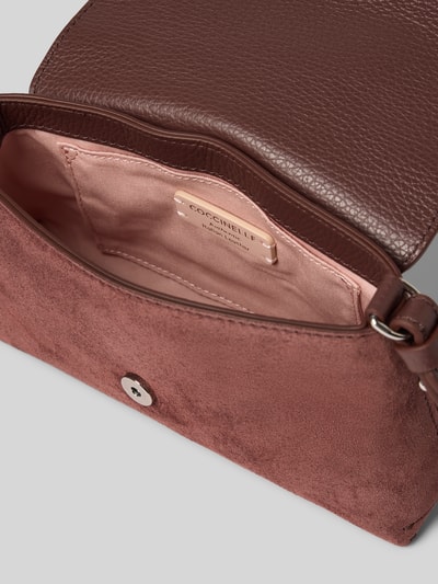 Produktfoto, Shoulder Bag aus echtem Leder Modell 'Nikla' von Coccinelle in Braun, Strukturmix aus glattem und rauem Leder, Überschlag mit Magnetverschluss, Innentasche, Hauptfach mit rosa Futter, Damen Shoulder Bag, 20x12x5 cm, Schulterriemen 128 cm.