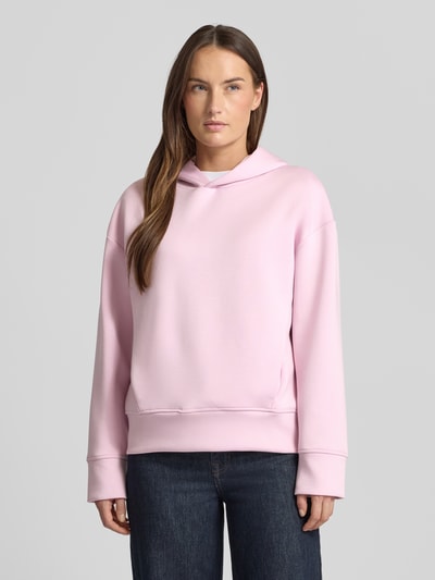 Vrouwenmodel draagt Regular Fit Hoodie aus Viskose-Mix mit Eingrifftaschen van Fynch-Hatton in lichtroze, elastische boorden, Ganzkörperaanzicht van voren.