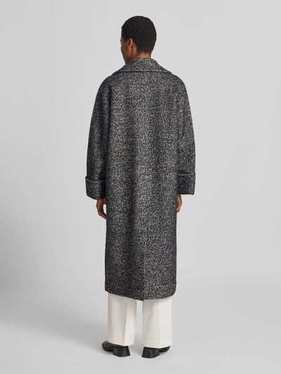 Frauenmodel trägt Mantel mit Woll-Anteil Modell 'ZAG' von Copenhagen Muse, melierte Optik, Relaxed Fit, Ganzkörperansicht Rückansicht.