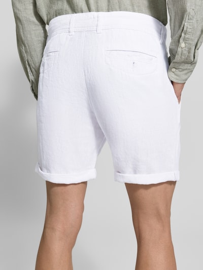 Männermodel trägt białe Leinenshorts mit Bindegürtel und Gesäßtaschen von MCNEAL z lnu, krój straight fit, zakładka, wyhaftowane logo, Ganzkörperansicht Rückansicht. Szerokość w rozmiarze M: 45 cm, długość wewnętrzna nogawki w rozmiarze M: 16 cm.
