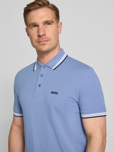 Męski model nosi Regular Fit Poloshirt aus reiner Baumwolle Modell 'PADDY' od BOSS Green, krój regular fit, niebieski, piqué, unikatowa tekstura, detalowy haft z logo, polokołnierzyk, 3-guzikowe zapięcie, krótki rękaw, widok na górną część ciała z przodu.