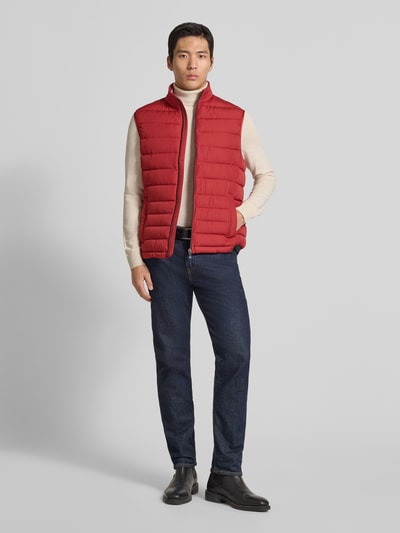 Männermodel draagt Steppweste mit Stehkragen van Christian Berg Men in rood, regular fit met ritssluiting en steekzakken, ganzkörperansicht van voren. Ruglengte maat M: 69 cm, schouderbreedte: 45 cm, borstwijdte: 57 cm.
