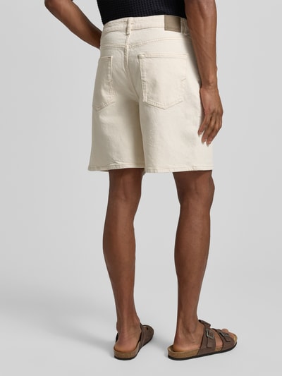 Männermodel trägt Relaxed Fit Jeansshorts aus Baumwoll-Mix Modell 'LOOSE ALEX SUMMER' von SELECTED HOMME in hellem Denim mit 5-Pocket-Design, Label Patch und Gürtelschlaufen, Ganzkörperansicht Rückansicht.