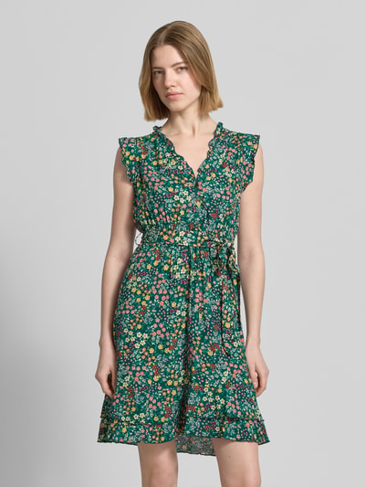 Frauenmodel trägt Minikleid aus reiner Viskose mit floralem Allover-Print von Apricot, Tailliert, Rüschenbesatz, V-Ausschnitt, Knopfleiste, Abnehmbares Taillenband, Ärmelloses-Design, Ganzkörperansicht von vorne.