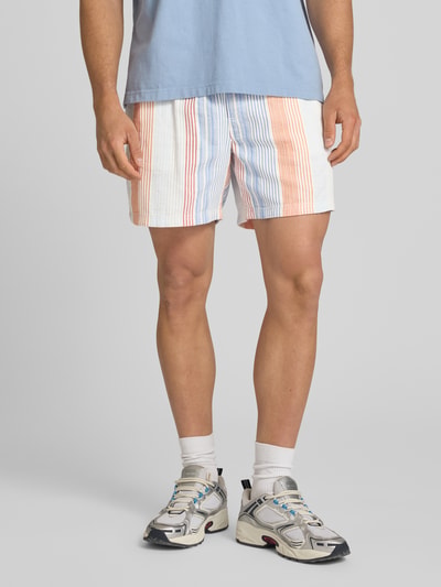 Mannenmodel draagt Relaxed Fit Shorts aus reiner Baumwolle van Tommy Jeans met all-over motief, relaxed fit, labelpatch, elastische boord met tunnelkoord, zij-steekzakken, dobby materiaalverwerking, puur katoen, Ganzkörperansicht van voren.