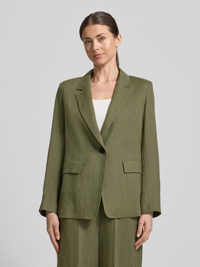Modelka kobieca nosi Regular Fit Blazer aus Leinen Modell 'VINCITA' od Emme, oliwkowy len, kołnierz z połami, zapięcie na guzik, kieszenie z patką, długość tyłu w rozmiarze 36: 68 cm, szerokość w rozmiarze 36: 48 cm, długość rękawów w rozmiarze 36: 64 cm, widok całej sylwetki z przodu.