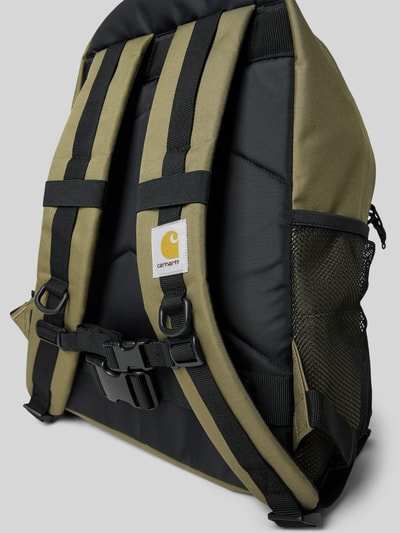 Produktfoto, Rucksack mit Label-Detail Modell 'KICKFLIP' von Carhartt Work In Progress, oliv und schwarz, gepolsterte, verstellbare Schulterriemen, Tragehenkel, Hauptfach mit Reißverschluss, Netzseitentasche, Maße 34 cm Breite, 45 cm Länge, 20 cm Tiefe, 70 cm Länge Schulterriemen