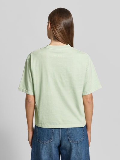Frauenmodel trägt Boxy Fit T-Shirt aus reiner Baumwolle von Marc O’Polo in Hellgrün, unifarben, Label-Schriftzug, Ganzkörperansicht Rückansicht.