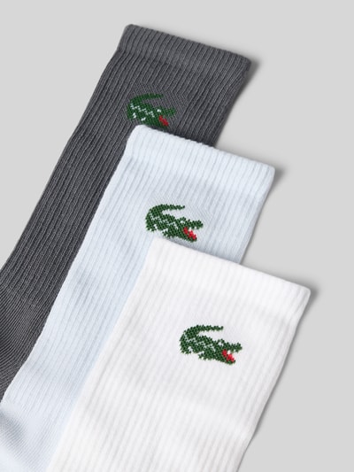 Produktfoto, Socken aus Baumwoll-Mix im 3er-Pack von Lacoste für Herren, gerippte Struktur in Grau, Hellblau und Weiß auf grauem Hintergrund.