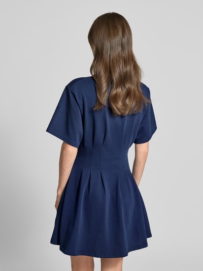 Modelka kobieca nosi Leicht ausgestelltes Sweatkleid aus reiner Baumwolle von Polo Ralph Lauren, melanż, krój lekko rozkloszowana, długość mini, okrągły dekolt, wyhaftowane logo, zakładki, rękaw krótki, wykończenie: dzianina dresowa, materiał: czysta bawełna, widok całej sylwetki z tyłu.